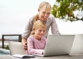 So like her mother. Shot of a young girl using a laptop while her mother looks on. Royalty Free Stock Photo