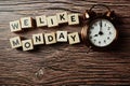 We Like Monday alphabet letter with alarm clock on wooden background