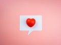 Like, social media icon with red heart ball on white speech bubble isolated on pink pastel background. Royalty Free Stock Photo