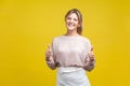 Like, thumbs up! Portrait of excited beautiful woman with fair hair in casual beige blouse, isolated on yellow background