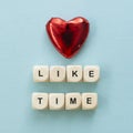 Like time words, made of wooden letters with red heart on blue background. Social media concept