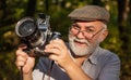 He likes birdwatching. Pension hobby. Experienced photographer. Vintage camera. Old man shoot nature. Professional