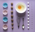 On a lilac background knolling walnut greek seeds sunflower sugar cube refined corn spoon egg round bowl cake mold flour blue pink