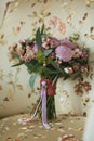 Lilac beautiful wedding bouquet with berries, standing on a white armchair with an overhead Royalty Free Stock Photo