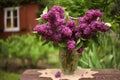 Lilac bouquet on knitted tissue in crystal vase close up vintage photo Royalty Free Stock Photo