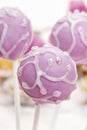 Lilac cake pops lavishly decorated with icing.