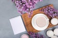 Lilac, coffee cup with latte art and marshmallow on white wooden table. Flat lay