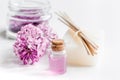 lilac cosmetics with flowers and spa set on white table background