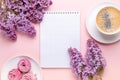 Lilac, cup of coffee, homemade marshmallow, notepad on pink background. Still life. Spring romantic mood. Top view Royalty Free Stock Photo