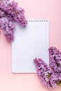 Lilac, cup of coffee, notepad on pink background. Still life. Spring romantic mood. Top view Royalty Free Stock Photo