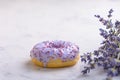 Lilac donut and bouquet of lavender on white natural marble background