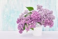 Lilac flowers bouquet in white vase on blue background. Holiday Royalty Free Stock Photo