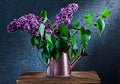 Lilac flowers in bronze watering can on black background Royalty Free Stock Photo