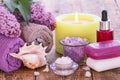 Lilac flowers, towels, red bottle with aromatic oil, burning candle, bowls with sea salt and soap Royalty Free Stock Photo