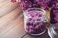 Lilac flowers in a jar, bunch of purple Syringa flowers on background. The preparation of infusion, aromatic sugar or jam