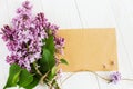 Lilac flowers on the wooden table. Greeting card.