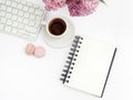 Lilac flowers on workdesk female home office with keyboard and coffee white background top view mockup Royalty Free Stock Photo