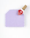 Lilac paper tag with a little christmas mitten pin