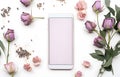 lilac pastel dried rose bud, herbs and leaves and phone on white wooden table background