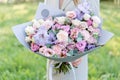 Lilac and pink pastel beautiful spring bouquet. Young girl holding a flower arrangement with various flowers. Bright