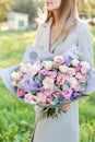 Lilac and pink pastel beautiful spring bouquet. Young girl holding a flower arrangement with various flowers. Bright Royalty Free Stock Photo