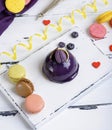 Lilac round cake with macarons on a white wooden board Royalty Free Stock Photo