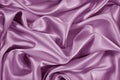 Lilac satin silk background. Soft wavy folds of delicate shiny fabric. Beautiful pink purple background for design. Royalty Free Stock Photo