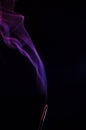 Lilac smoke incense sticks on a black background Royalty Free Stock Photo