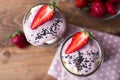 Lilac smoothie in two jars on wooden background with strawberry and bananas