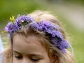 Lilac wreath on the head of a little blonde girl