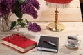 Lilacs, book, notebook, spectacles, cup of tea and table lamp