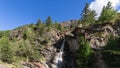 Lillaz waterfall splashes alpine water and breaks through crevice of granite rocks in Gran Paradiso Park