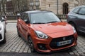 Front view of orange suzuki swift sport parked in the street