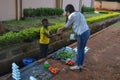 LILONGWE, MALAWI, AFRICA - APRIL 2, 2018: An African Malawian little boy is selling tomatos, fish and green leaves along the road