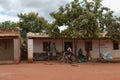 LILONGWE, MALAWI, AFRICA - APRIL 1, 2018: Africans are sitting at house, speaking with woman on the bycicle along the road where