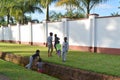 LILONGWE, MALAWI, AFRICA - APRIL 2, 2018: Local children are plaing on the ground with bright green grass near white fence and