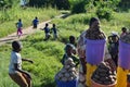 LILONGWE, MALAWI, AFRICA - MARCH 25, 2018: African woman is selling potatos and children are smiling, playing and running away.