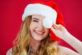 a lilt beautiful woman in a Santa Claus hat on a red background. Royalty Free Stock Photo