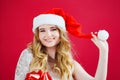 a lilt beautiful woman in a Santa Claus hat on a red background. Royalty Free Stock Photo