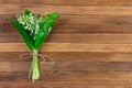 Lily of the valley flower bouquet tied with twine on wooden retro grunge background Royalty Free Stock Photo