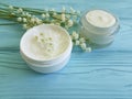 Lily of the valley flower cosmetic cream on blue wooden Royalty Free Stock Photo