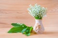 Lily of the valley flowers in vase on wooden background Royalty Free Stock Photo
