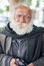 LIMA, PERU - APRIL 15, 2013: Unknown Homeless person with gray beard eating sweets in Lima, Peru.