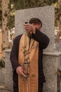 Greek Orthodox priest shaking incense and praying a blessing at the cemetery Royalty Free Stock Photo