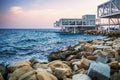 Limassol waterfront with yellow stones, blue sea and empty cafes and bars at sunset, Cyprus