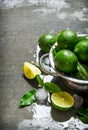 Lime background. Fresh limes in a saucepan with slices and leaves around. Royalty Free Stock Photo