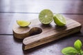 Lime and basil on wooden board