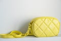 Lime cross body bag. Ladies bright-colored handbag on gray background. Yellow bag