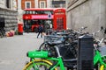 A Lime electric assist rental bike parked with regular bicycles with a Red London Double Decker Bus, a traditional red phone box Royalty Free Stock Photo