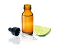 Lime essential oil in glass bottle and fresh green lime fruit isolated on white Royalty Free Stock Photo